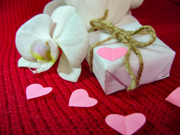 Orchidea e cuori su stoffa rossa, sfondo di San Valentino, giorno del matrimonio . — Foto Stock