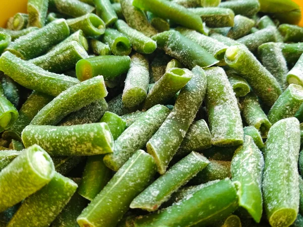 Grüne gefrorene Bohnen. Nahaufnahme frozen cut green french bean, haricot vert. pflanzliche Lebensmittel Hintergrund. — Stockfoto