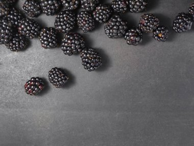 Siyah arkaplanda taze böğürtlenler