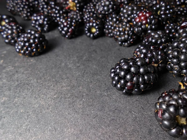 Siyah arkaplanda taze böğürtlenler