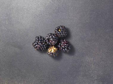 Siyah arkaplanda taze böğürtlenler.