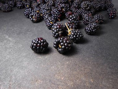 Siyah arkaplanda taze böğürtlenler.