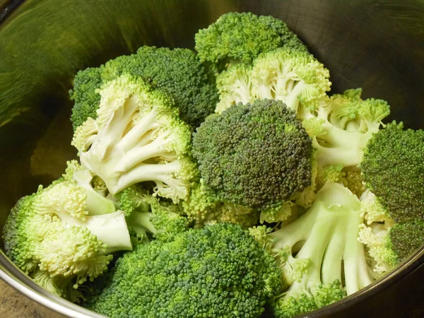 Fresh raw broccoli in a metal pan on a dark background. Broccoli florets ready for cooking. — Stock Photo, Image