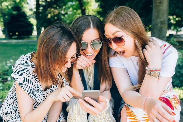 Happy friends in the park on a sunny day . Summer lifestyle portrait of three multiracial women enjoy nice day, wearing bright sunglasses. Taking picture on mobile phone. Best friends girls having fun — Stock Photo, Image