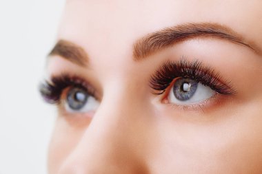 Kirpik uzatma prosedürü. Uzun kirpikli kadın gözü. Yaklaş, seçici odaklanma.