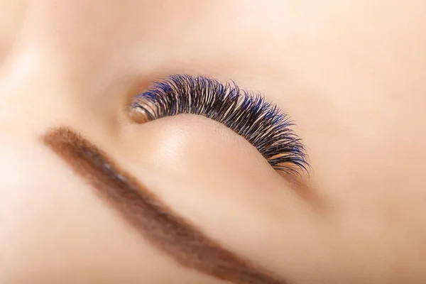 Wimper extensie Procedure. De ogen van de vrouw met lange blauwe wimpers. Ombre effect. Close-up, selectieve aandacht. — Stockfoto