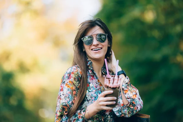 Junge Frau mit Sonnenbrille und Milchshake. Outdoor Herbst Lifestyle Porträt von hübsch lächelnd weiblich. — Stockfoto