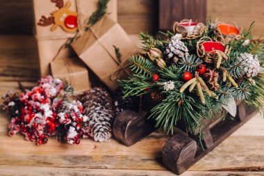 Ahşap arka plan üzerinde kutuları ile Noel hediyeleri. Vintage tarzı. Portre, seçici odak. Oyuncak, ayı, kızak. Noel kavramı.