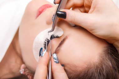 Kirpik uzatma prosedürü. Uzun kirpikli kadın gözü. Yaklaş, seçici odaklanma.