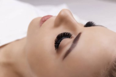 Kirpik uzatma yordamı. Kadın gözü ile uzun kirpiklerini. Yakın, seçici odak. Hollywood, Rus güç