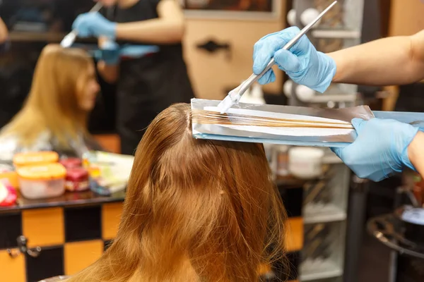 Professionelle Friseurin färbt Haare ihrer Kundin im Salon. Selektiver Fokus. — Stockfoto