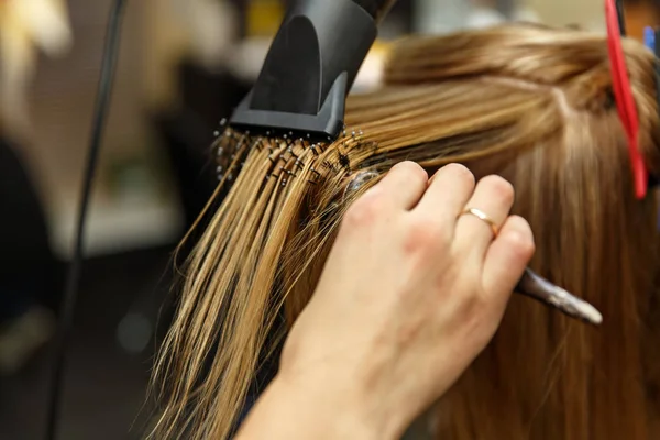 Profesionální kadeřnictví, barvení vlasů svého klienta v salónu. Haircutter suché vlasy s vysoušečem vlasů. Selektivní fokus. — Stock fotografie