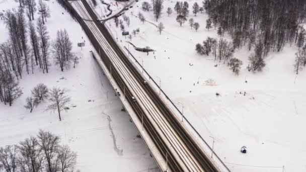 美しい都市や町で雪の降る冬。クリップ。凍った川、道、古代の建物の多くの車の平面図です。大都市の魅力的な冬の期間です。素晴らしいパノラマ — ストック動画