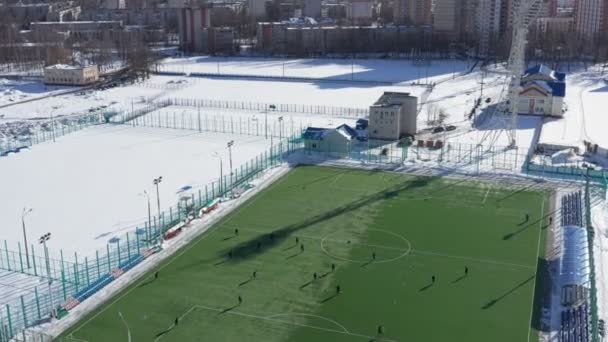 Αεροφωτογραφία της ποδοσφαιρικής ομάδας εξάσκηση την ημέρα σε γήπεδο ποδοσφαίρου στην κάτοψη. Κατάρτιση junior ποδοσφαιρική ομάδα στο αθλητικό έδαφος με ένα πράσινο γκαζόν σε μέρα του χειμώνα — Αρχείο Βίντεο