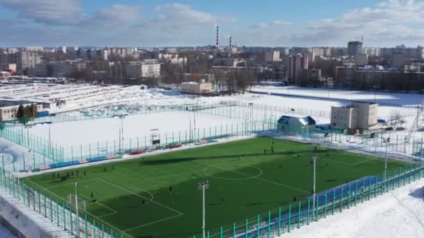 Tiro aéreo del campo de fútbol amateur. tiro de un campo de fútbol moderno con un diseño blanco en invierno. Imágenes de 4k — Vídeo de stock