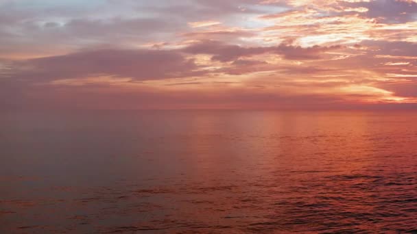 Vliegen op zonsondergang tijd. Mooie rode hemel, wolken, zee. 4 k luchtfoto panorama. Oceaan, zee oppervlak in zonsopgang, zonsondergang tijd met prachtige wolken en zon reflectie in water — Stockvideo