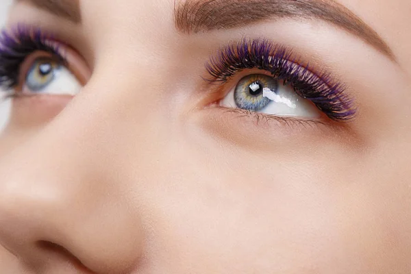 Wimpernverlängerung. Frauenauge mit langen blauen Wimpern. ombre-Effekt. Nahaufnahme, selektiver Fokus. — Stockfoto