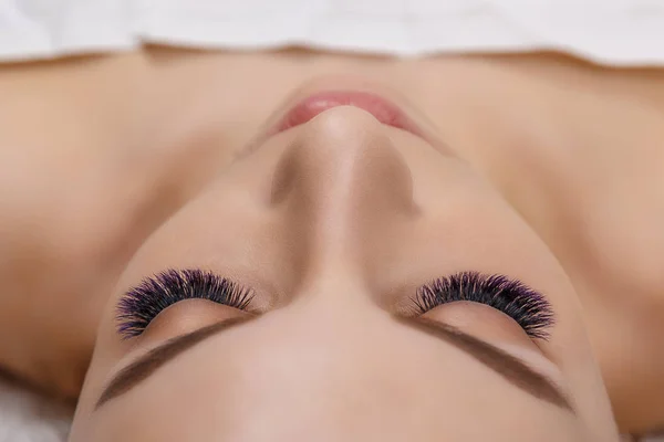 Kirpik uzatma yordamı. Kadın uzun mavi kirpik gözle. Ombre etkisi. Yakın, seçici odak.