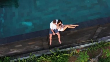 Romantik yaz tatilinde lüks tatil beldesinde aşık çift. İnsanlar Edge Yüzme Havuzu birlikte rahatlatıcı , Güzel günbatımı Deniz Manzarası Zevk. Balayı seyahatinde mutlu aşıklar. Ilişki
