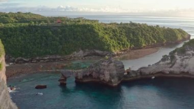 Nusa Penida adasının yeşil tropikal sahil havadan görünümü, Atuh plaj, Bali, Indonesia.Clear mavi okyanus dalgaları plaja haddeleme. 4k