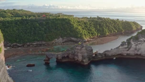 Vista aerea della costa tropicale verde dell'isola di Nusa Penida, spiaggia di Atuh, Bali, Indonesia.Clear onde blu oceano rotolando verso la spiaggia. 4K — Video Stock