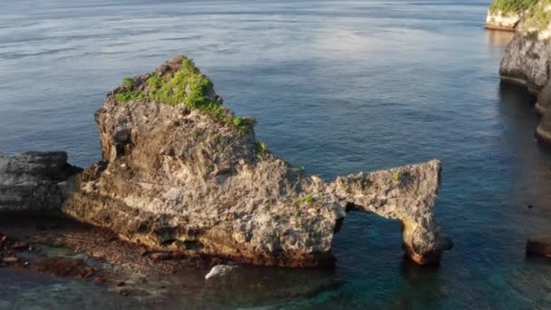 Вид з повітря на зеленому тропічному узбережжі острова Нуса-Пеніда, Atuh Beach, Балі, Індонезія. чіткі блакитні Океанські хвилі котяться до пляжу. 4K — стокове відео