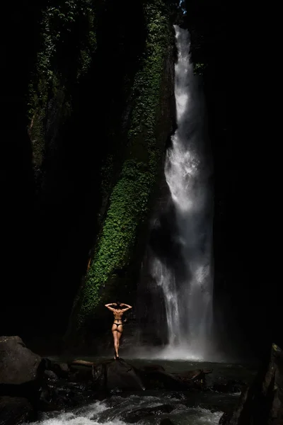 Belle jeune femme en bikini se relaxant devant la cascade. Écotourisme concept image voyage fille — Photo