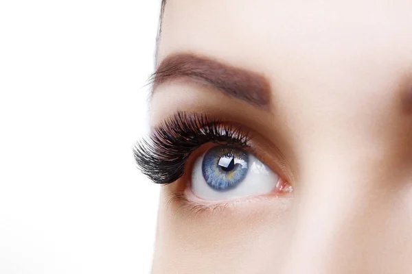 Ögonfrans förlängning förfarande. Kvinna öga med lång blå ögonfransar. Ombre effekt. Närbild, selektivt fokus. — Stockfoto