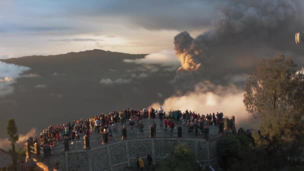 Drone vista aérea do vulcão ativo Bromo. Nascer do sol, multidão de turistas no ponto de vista. 4K curto . — Vídeo de Stock