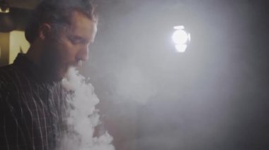 Adam vape dükkanında elektronik sigara içiyor. Yavaş çekim.