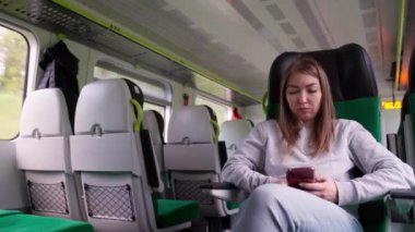 Trende akıllı telefon kullanan bir kadın..