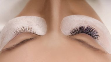 Kirpik uzatma prosedürü. Uzun kirpikli, pürüzsüz, sağlıklı ciltli güzel bir kadın gözü..