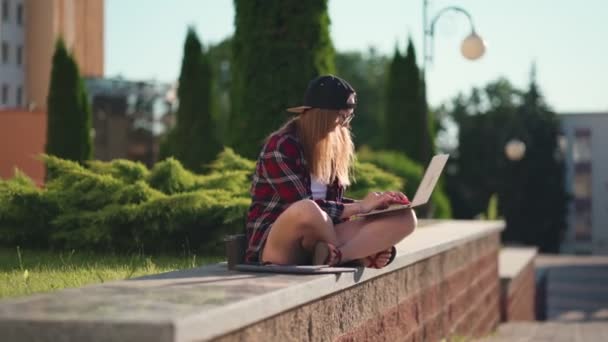 Vysokoškolák pracující na laptopu v kampusu. Krásná mladá studentka sedí v blízkosti univerzity a pomocí přenosného počítače. — Stock video