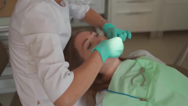 Kvinnlig tandläkare ta bort tandställning patienten tänder på tandvårdskliniken kontor. Medicin, tandläkarkoncept. Tandläkarutrustning. Närbild. — Stockvideo