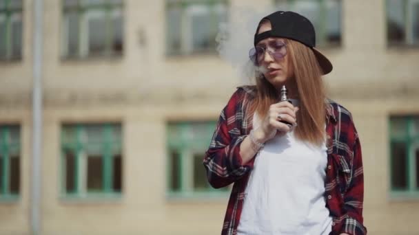 Jolie jeune femme hipster en bonnet noir vape ecig. Fille vape gadget ecig populaire, vaping device.Happy fille vaper brune avec e-cig. Portrait de fumeuse modèle féminin avec cigarette électronique — Video