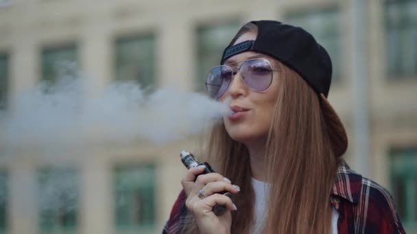 Feche bem jovem hipster mulher de chapéu preto vape ecig. Menina vape gadget ecig popular, vaping device.Happy morena vaper menina com e-cig. Retrato de fumante modelo feminino com cigarro eletrônico — Vídeo de Stock