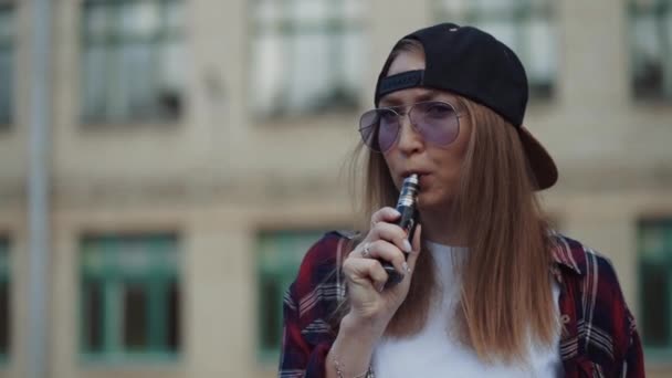 Feche bem jovem hipster mulher de chapéu preto vape ecig. Menina vape gadget ecig popular, vaping device.Happy morena vaper menina com e-cig. Retrato de fumante modelo feminino com cigarro eletrônico — Vídeo de Stock