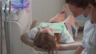 Kadın dişçi, dişçi muayenehanesindeki diş telleriyle hasta dişlerini kontrol etmeye hazırlanıyor. Tıp, dişçilik konsepti. Diş ekipmanları.