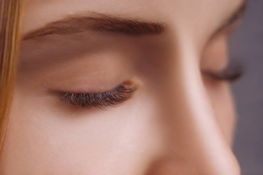 Kirpik uzatma prosedürü. Uzun kirpikli kadın gözü. Yaklaş, seçici odaklanma.