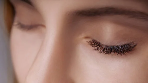 Διαδικασία επέκτασης βλεφαρίδων. Γυναικείο μάτι με μακριές βλεφαρίδες. Κλείσιμο, επιλεκτική εστίαση. — Φωτογραφία Αρχείου
