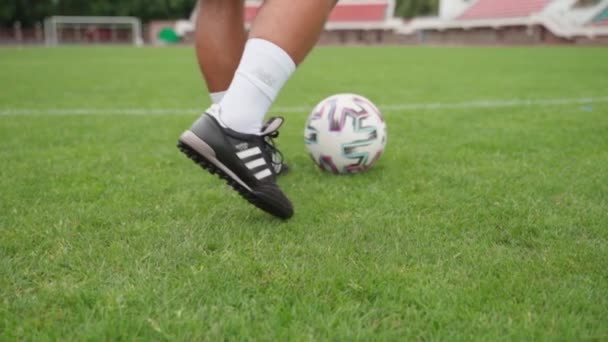 BREST, BELARUS - 2020年8月1日若い男サッカー選手は、緑のサッカー場でサッカーボールをキックボールをキックする準備をします。スローモーションショット. — ストック動画