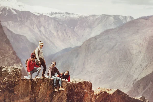 Turist cliff karşı dağlar üzerinde Grup — Stok fotoğraf