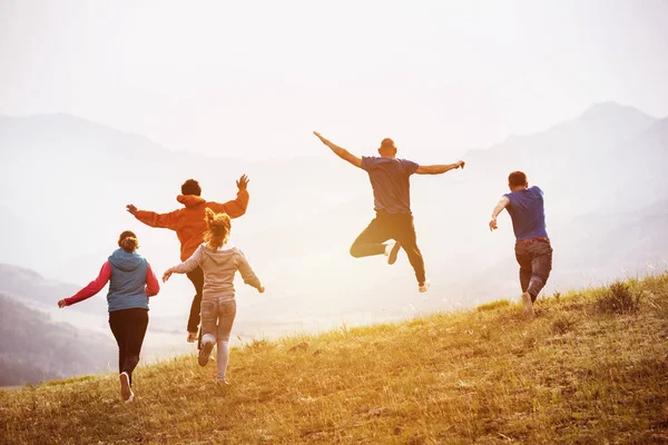 Glückliche Freunde rennt und springt im Freien — Stockfoto