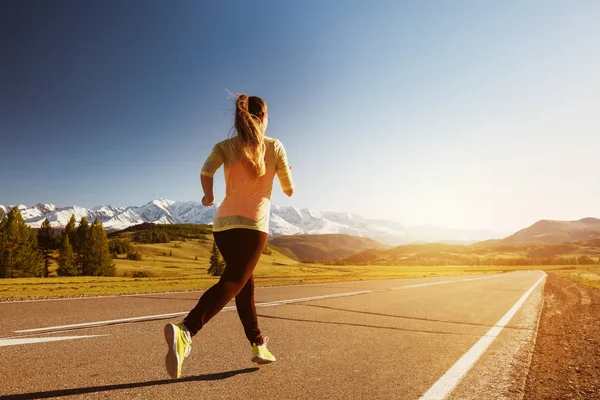 Woman running straight road mountains outdoors — Stock Photo, Image