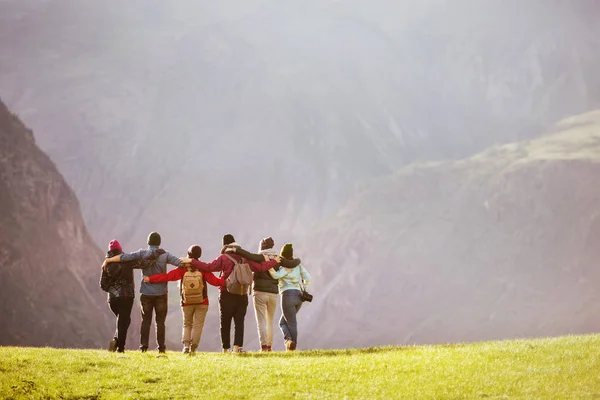Groep vrienden knuffelen tegen bergen vallei — Stockfoto