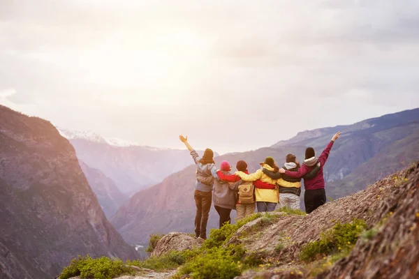 Happy vrienden cliff tegen bergen — Stockfoto