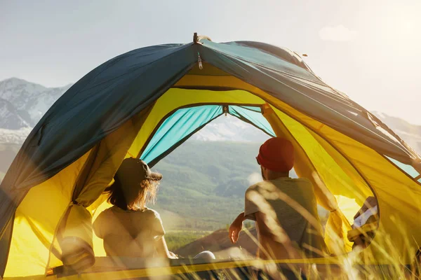 Casal resto na tenda contra o pôr do sol montanhas — Fotografia de Stock