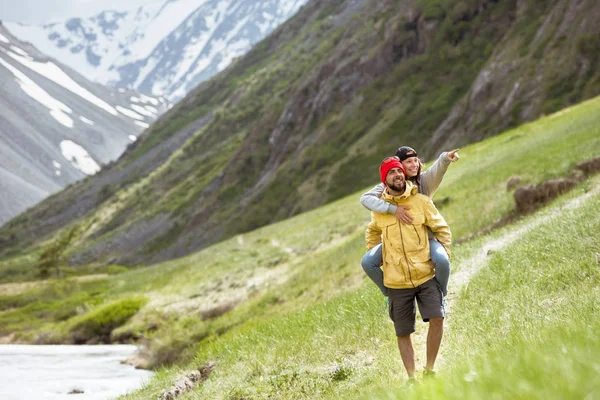 Happy couple marcher montagnes piggyback — Photo