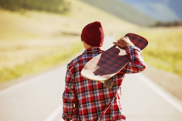 Mannen med skate promenader på väg — Stockfoto