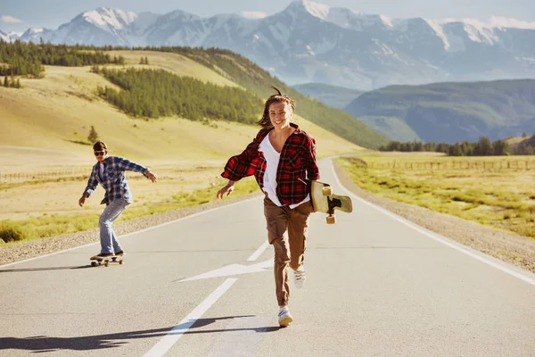 Amigos felizes com patins e longboards estão se divertindo — Fotografia de Stock